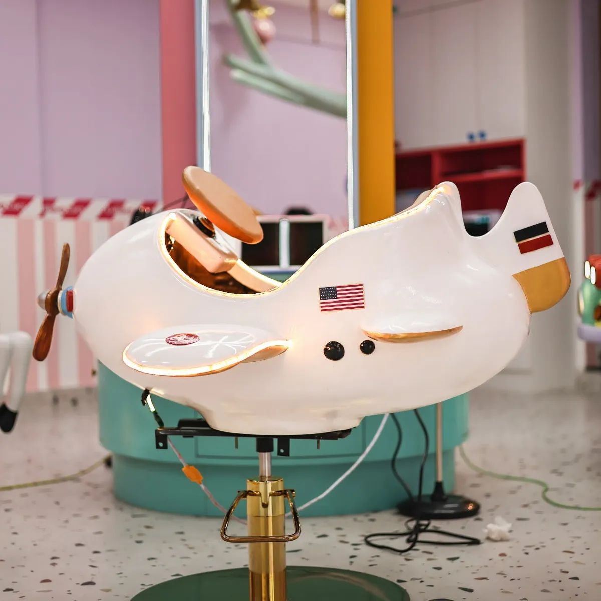 White airplane-themed kids haircut chair at Lollipop Locs