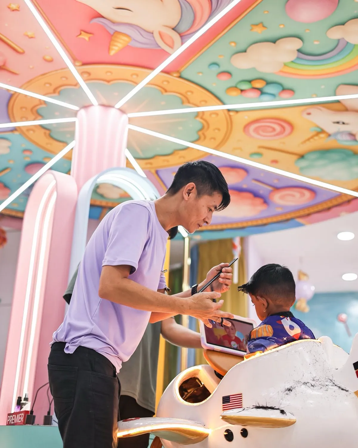 Kids haircut in Electronic City — stylist giving a child a haircut in a themed chair at Lollipop Locs