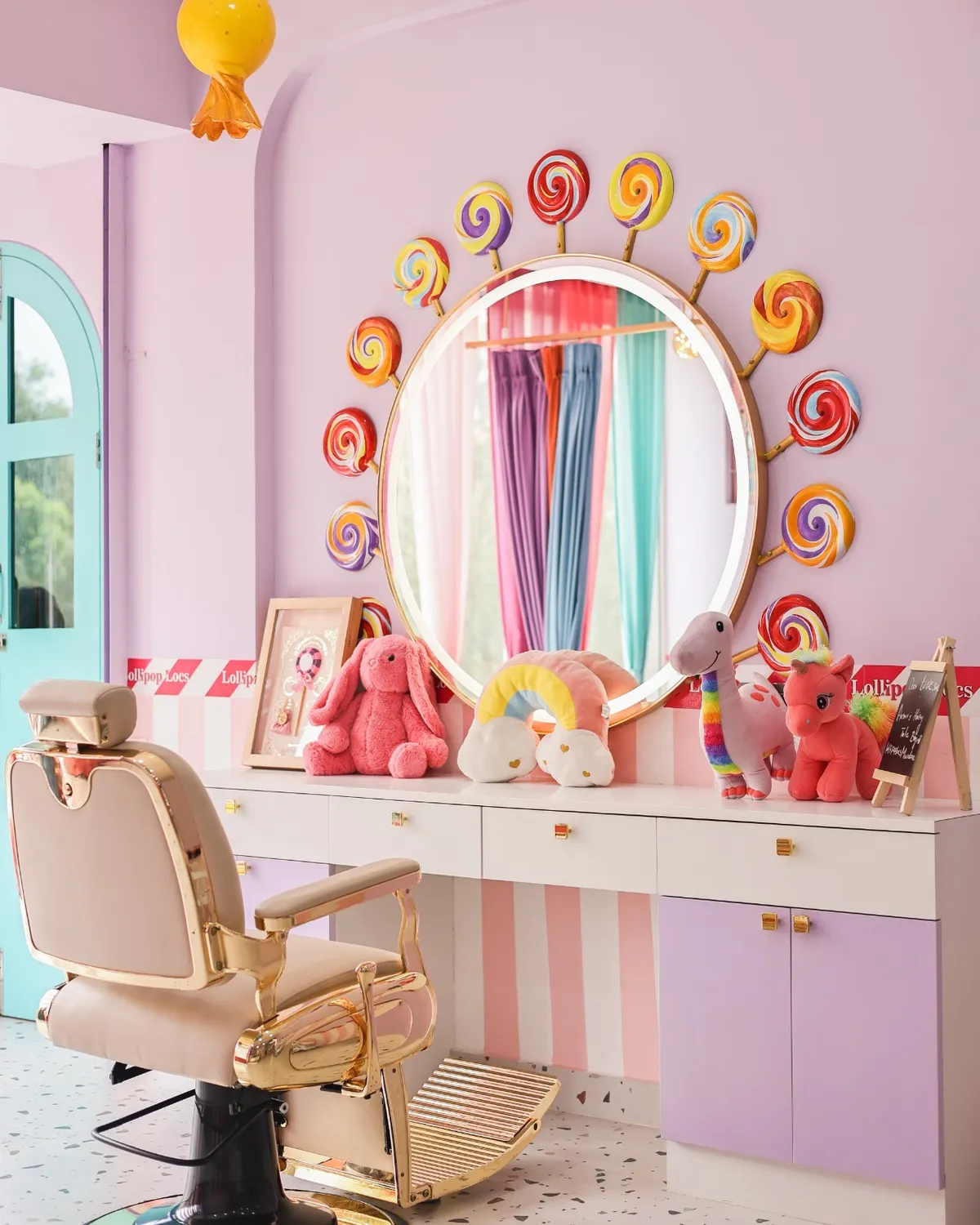 Styling station with a lollipop-framed mirror and salon chair at Lollipop Locs
