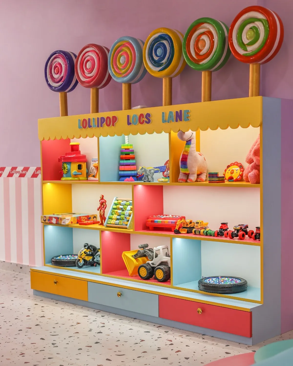 Illuminated toy shelf labelled Lollipop Locs Lane